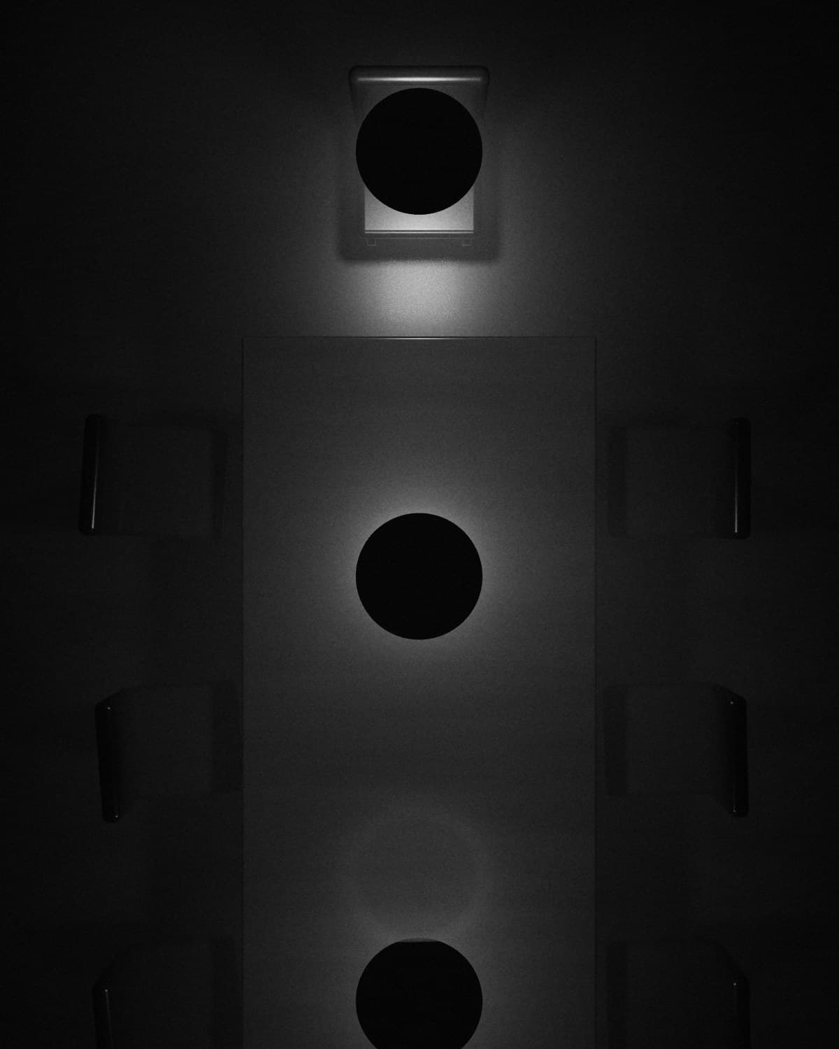 Seen from above: the head of a long table, chairs on either side, lamps hanging over it.